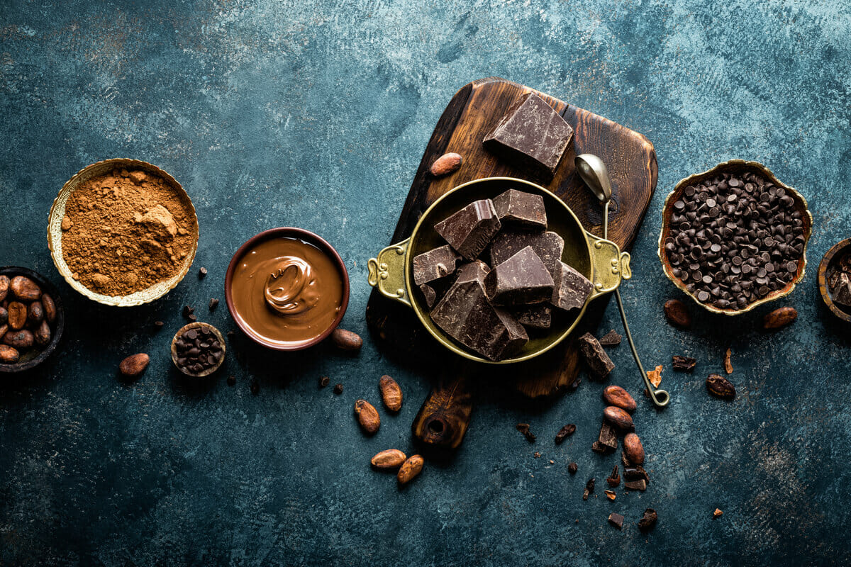 Dark chocolate pieces crushed and cocoa beans, culinary background, top view