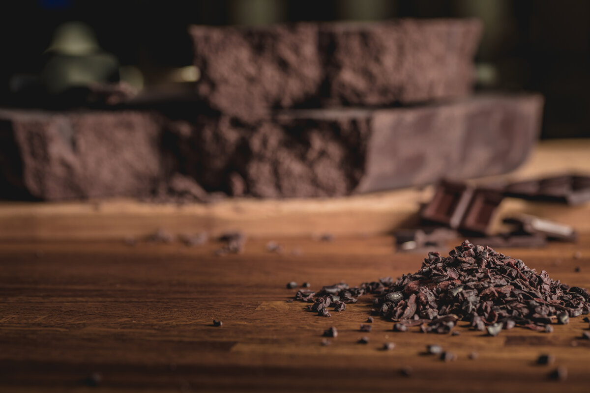 Sweet arrangement of cocoa beans and chocolate bars on wooden surface for chocolate production