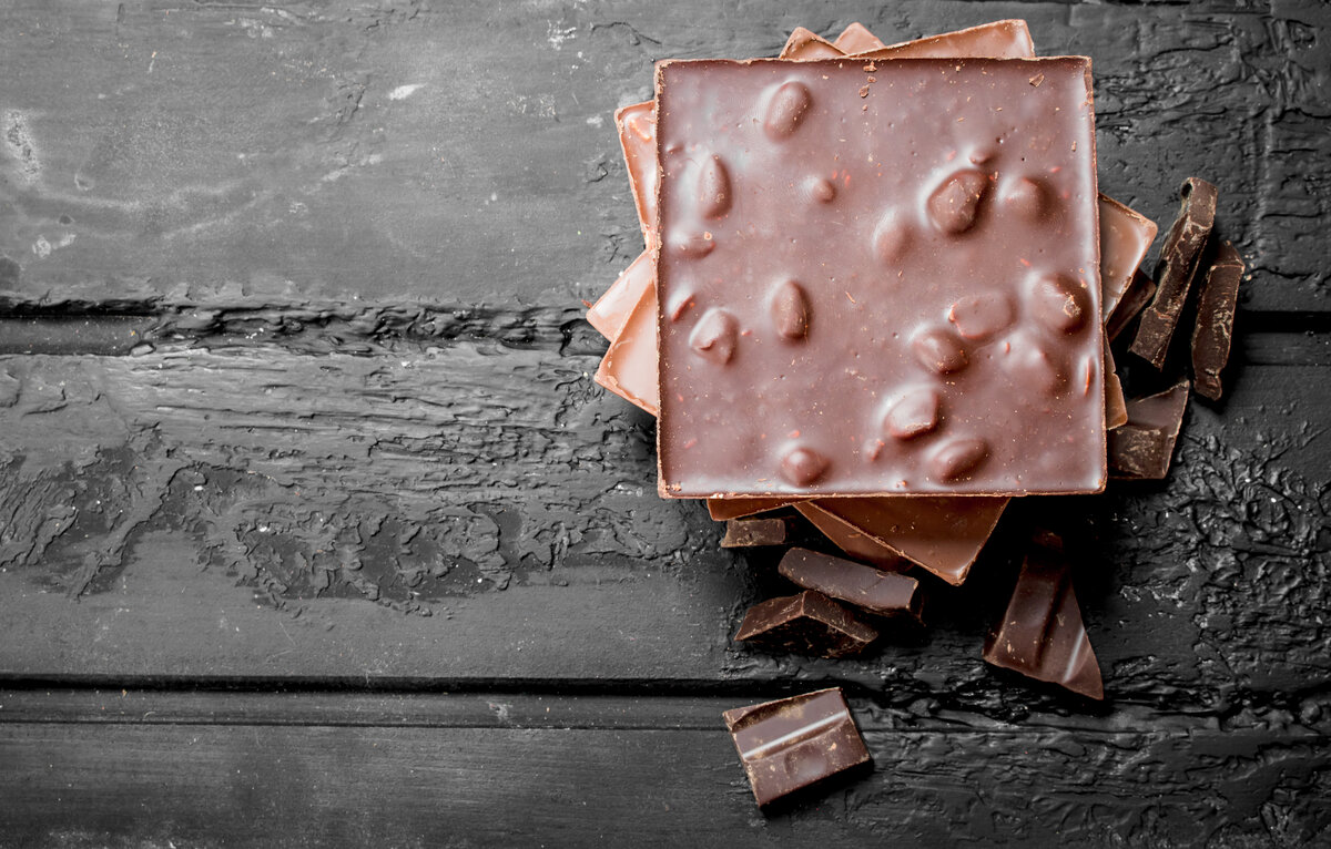 Different types of chocolate. On black rustic background.