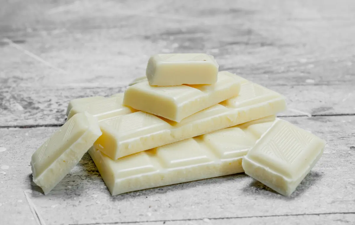 Is White Chocolate Really Chocolate? 8 Pieces of white chocolate. On a rustic background.