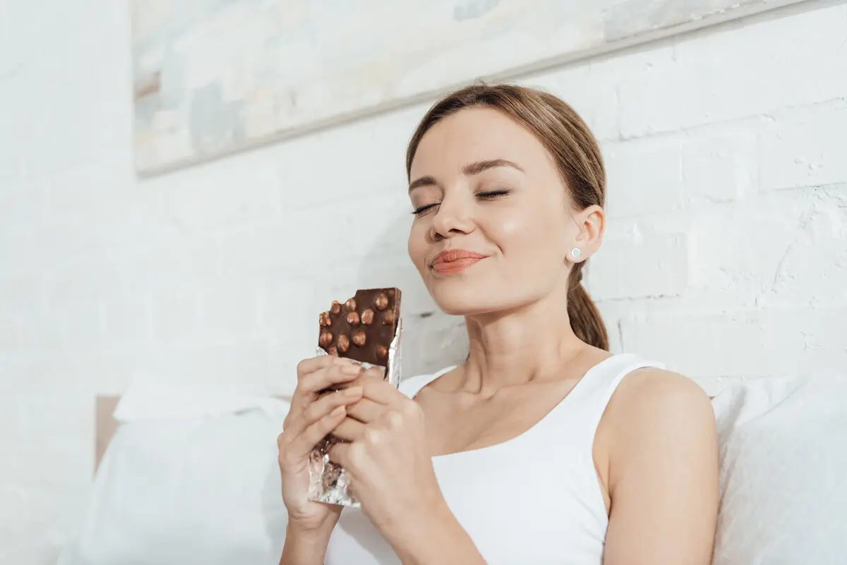 Ways to Treat Yourself in the New Year 3 low angle view of smiling young woman eating choco treat yourself